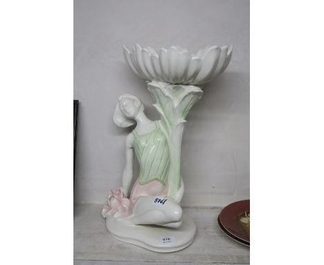 A CONTINENTAL PORCELAIN FIGURAL PLANTER modelled as a young girl shown reclining holding a scallop shaped bowl aloft