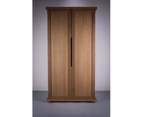 AN UPRIGHT OAK TWO DOOR WARDROBE, BY PHILIPPE HUREL, the panel doors opening to reveal a shelved interior, 228cm (h) x 122cm 