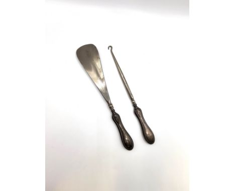 A silver handled shoe horn with a beaded border 21.5cm, 21.5cm and a matching button hook by William Aitken, Birmingham 1913.
