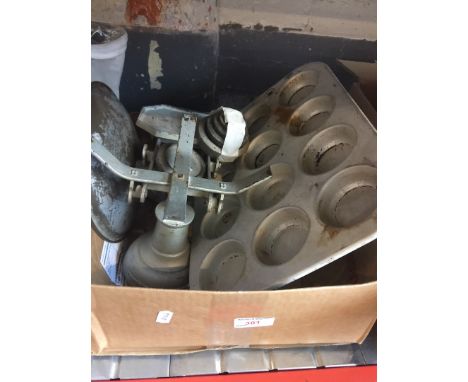 A box containing weighing scales and baking tins 
