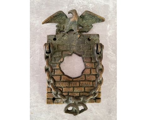 An unusual early 20th century brass 'Hole In The Wall' door knocker / door bell surround surmounted with an Eagle, chain link