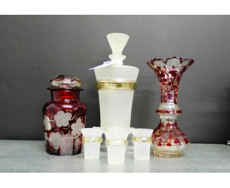 An opaque glass decanter and stopper with four shot glasses together with a ruby flashed glass vase, jar and cover (7)