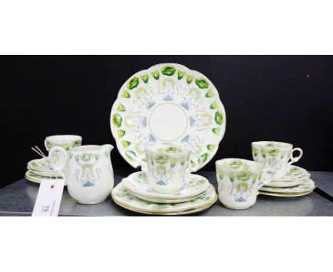 An Art Nouveau white glazed porcelain teaset painted with stylised flowers in green and blue comprising cake plate, four cups