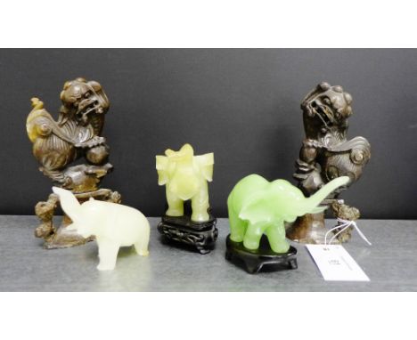 A green jade elephant together with two soapstone elephants and a pair of soapstone temple dogs, each on a shaped stand (5)