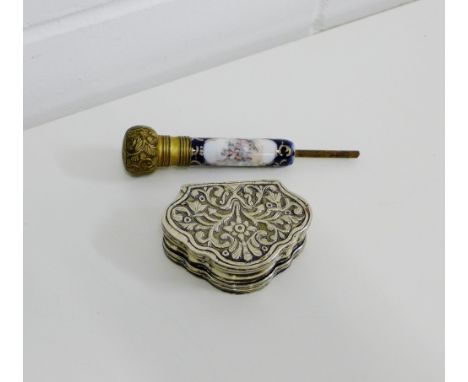 A porcelain and brass mounted parasol handle, together with a white metal repousee decorated snuff box (2)