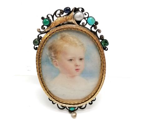 Antique portrait miniature of a child in a gilt metal frame with locket reverse and with cornucopia shell detail set with gem