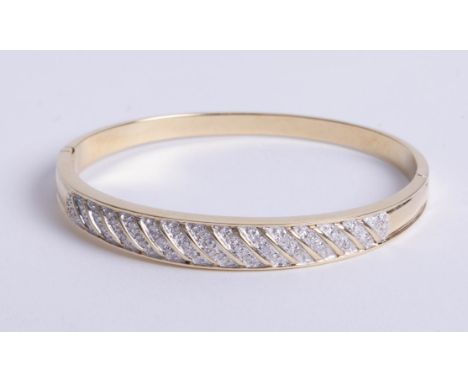 A 9ct yellow gold hinged bangle, pavé set diamond top section with graduated gold bars, box snap and side safety catch.