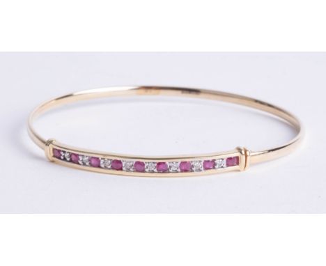 A 14ct ruby and diamond set bangle, 5.40g.