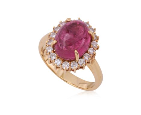 A PINK TOURMALINE AND DIAMOND 'HALO' RING Featuring a pink tourmaline cabochon weighing approximately 6.0 Cts, mounted in a h