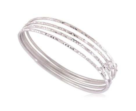 A GROUP OF FOUR WHITE GOLD BANGLES
Featuring a group of four white gold bangles each marked '18K' alongside various other mar