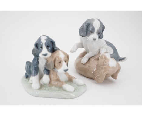 Two Nao figurines modelled as puppies at play, 14 cm and 11 cm high