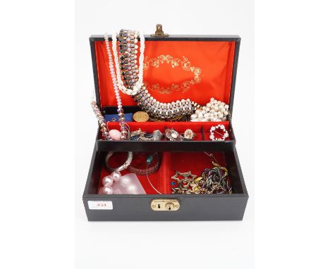 A vintage jewellery box containing a quantity of costume jewellery, including brooches, rings and ear pendants