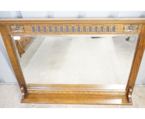 A carved-oak overmantel mirror with integral shelf and bevel-edged plate, 107 cm x 92 cm high