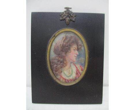 An Edwardian portrait miniature, the head and shoulders of a woman with long brown wavy hair, wearing a green bead necklace a