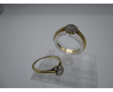 Two gold rings one set with seven diamonds, stamped 18 and the other a solitaire diamond ring in an illusion setting, 3.8g 