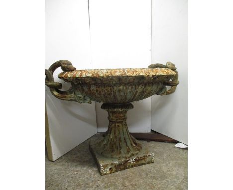 A Victorian cast iron garden planter of shallow urn design with twin opposing entwined swan neck and head handles, an egg and