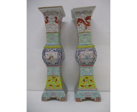 A pair of late 19th/early 20th century Chinese famille rose square beaker vases, with a flared neck, a panelled body, splayed