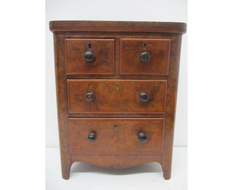 A Victorian traders sample of a walnut chest of two short and two long drawers, with turned handles, a shaped apron and brack