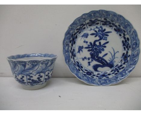 An early 18th century Kangxi blue and white cup and saucer, each with a fared wavy lip, the cup decorated with panels of flow