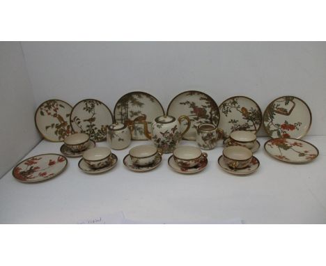 An early 20th century Japanese Satsuma teaset decorated with various birds perched in branches, in tones of green, orange, pu