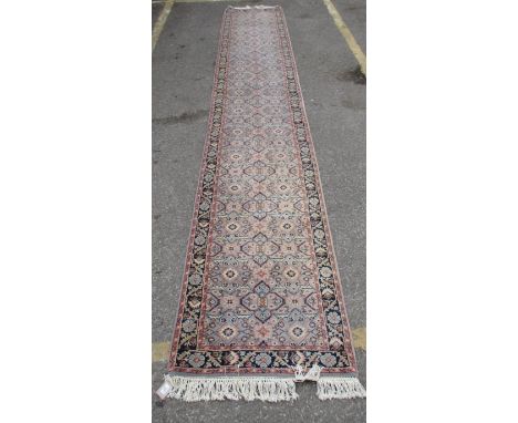 A Persian design runner with repeated geometric flowers and motifs on a pale blue ground, 33" x 197" 