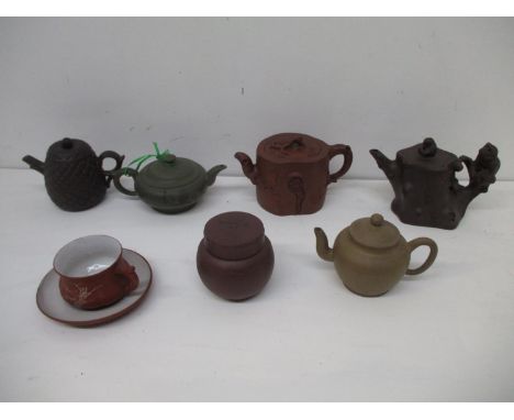A group of Chinese Yixing Zisha pottery teapots, a pot and cover and a tea cup and saucer to include an example decorated wit