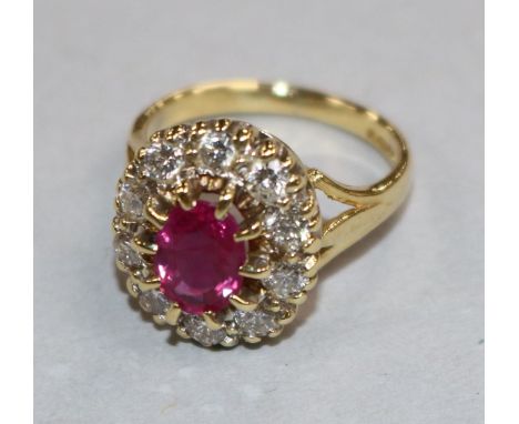 A modern 18ct gold, ruby and diamond oval cluster ring, size F.