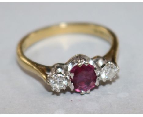 A modern 18ct gold and three stone ruby and diamond ring, size N.