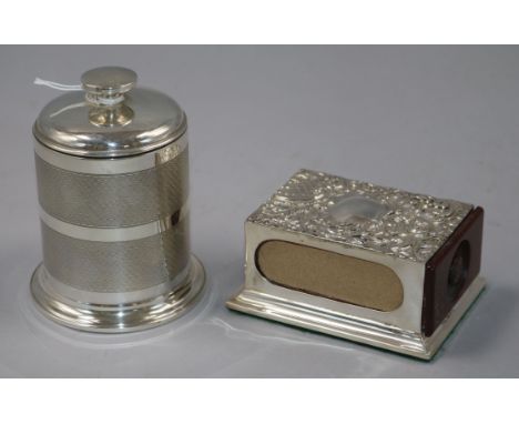 A 1930's engine turned silver cylindrical cigarette dispenser, Birmingham, 1935 and a repousse silver matchbox holder on plin