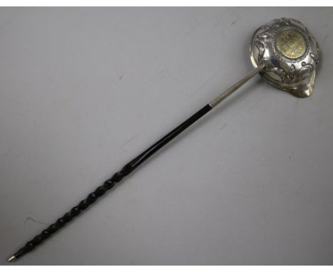 An 18ct century embossed silver toddy ladle with baleen handle and bowl with inset coin, 33cm.