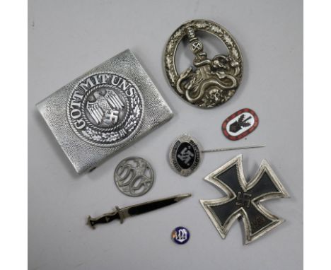 A German Iron Cross 1st class, an SS lapel badge number 792, dagger lapel pin, German army belt buckle, three German badges w