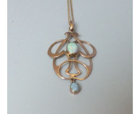 A 9CT GOLD ART NOUVEAU STYLE PENDANT AND CHAIN, the pendant of sinuous form, set with a central opal cabochon, terminating wi