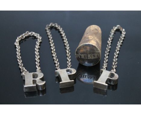 THREE STYLIZED WHITE METAL DECANTER LABELS, two 'P' for Port and a R for Rum, together with cork topper 'Whiskey' (4)