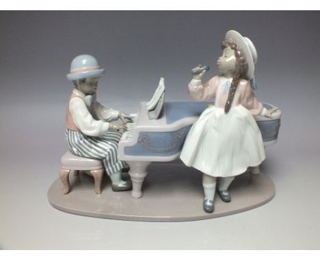 LLADRO 5930 - 'JAZZ DUO', large group figure depicting young boy playing the piano with young girl singing, overall L 32.5 cm