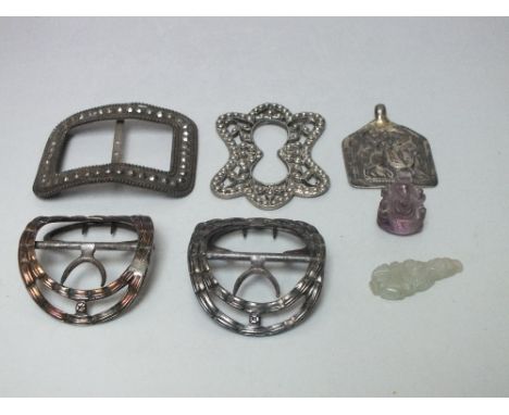 A SELECTION OF WHITE METAL BUCKLES ETC, together with a carved amethyst deity, and a small jadeite pendant (7)
