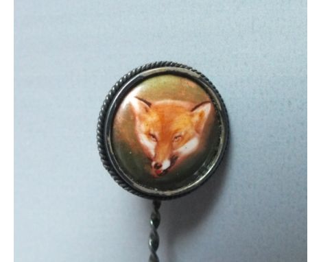 AN EARLY 20TH CENTURY SILVER FOX HEAD STICK PIN, the circular panel painted with fox mask image, impressed 'Sterling' to the 