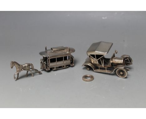 A NOVELTY DUTCH SILVER MODEL OF A 1909 OPEL COUPE,  together with a similar white metal model of a horse drawn tram, both a/f