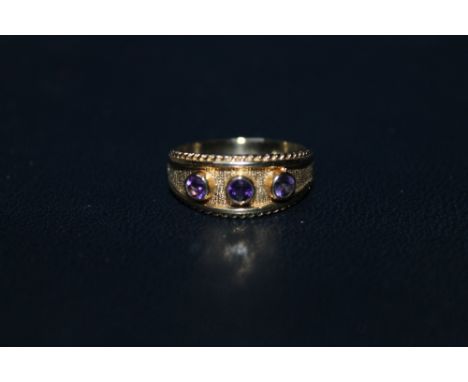 A HALLMARKED 9 CARAT GOLD AMETHYST THREE STONE RING, ring size O