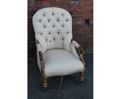 A VICTORIAN MAHOGANY UPHOLSTERED ARMCHAIR, with button backed upholstery, scroll arms, raised on turned supports, castors