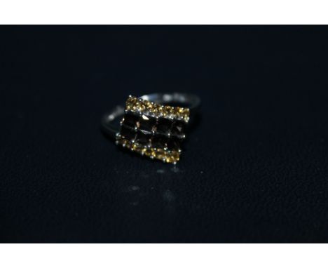 A 9K WHITE GOLD SMOKEY QUARTS RING, with yellow sapphire type stones either side, ring size R