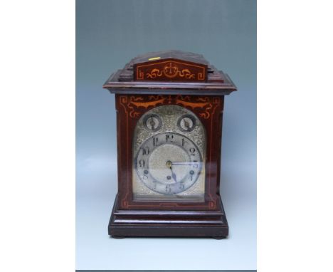 AN EDWARDIAN INLAID MAHOGANY QUARTER CHIMING TABLE CLOCK, the silvered face with scrolling foliate decoration, silvered chapt