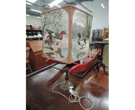 A brass based lamp with four panel water fowl light shade