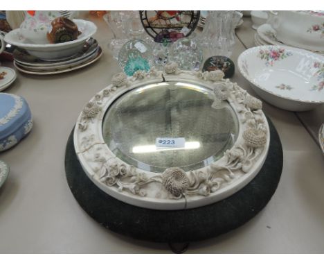 A Victorian oval wall mirror having ceramic foliate frame