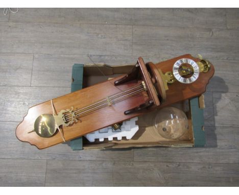 A wall hanging skeleton clock under glass dome with winder and weight, 93cm total length 