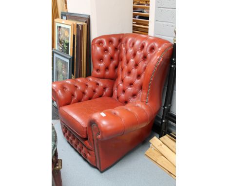 A red button leather Chesterfield armchair 