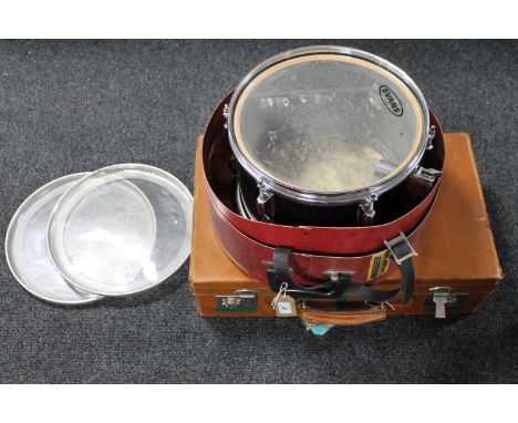 A vintage leather luggage case together with a drum case containing an Evans drum with skins