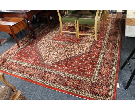 A large machine-made Indian carpet on red ground, 346cm by 250cm