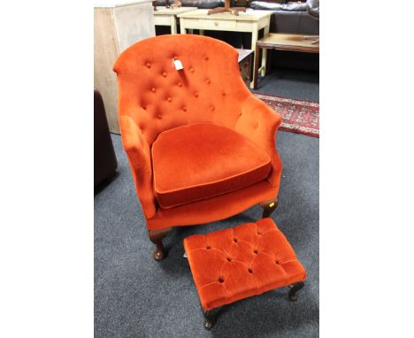An Edwardian armchair in red/orange button fabric and a modern footstool 