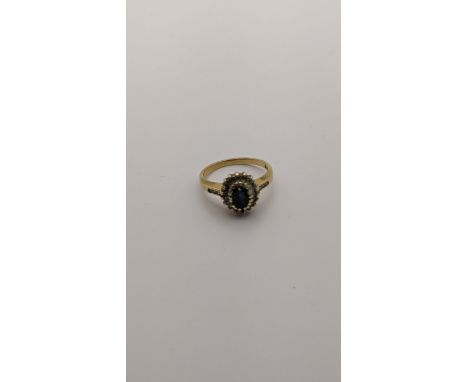 An 18ct gold ring set with a blue sapphire and diamonds 3.8g Location: 