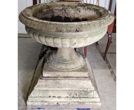 A large reconstituted stoneware planter fashioned as an urn raised on a stepped square base 92cm h x 89.5cm w Location: 